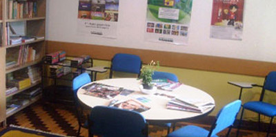 Sala de aula com parte da biblioteca da escola.